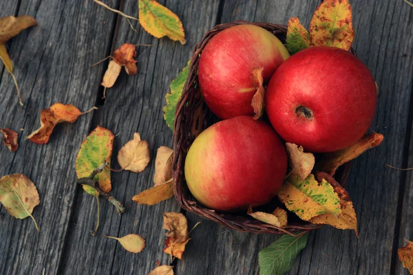 Manzana sobre mesa de madera con hojas caídas de otoño —  Fotos de Stock