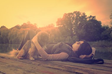 Vintage photo of relaxing woman with her dog on a pier clipart