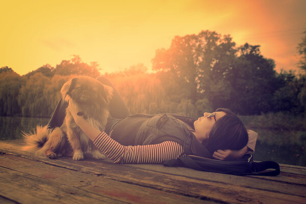 Vintage photo of relaxing woman with her dog on a pier