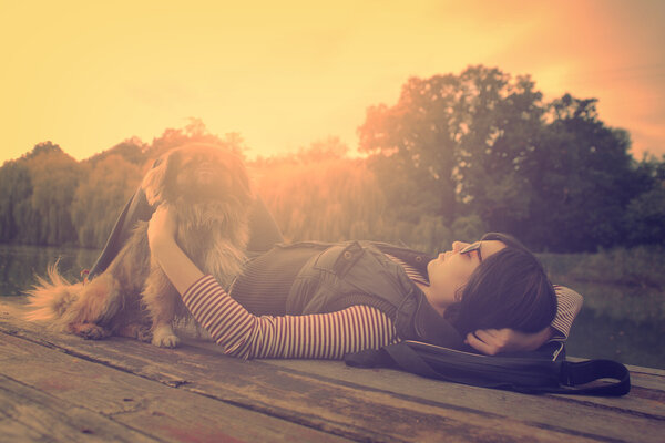 Vintage photo of relaxing woman with her dog on a pier