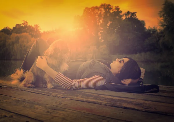 Vintage foto de la mujer relajante con su perro en un muelle — Foto de Stock