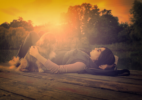 Vintage photo of relaxing woman with her dog on a pier