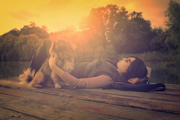 Vintage photo of relaxing woman with her dog on a pier