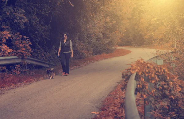 Vintage photo of young woman walking with her dog — Stock Photo, Image