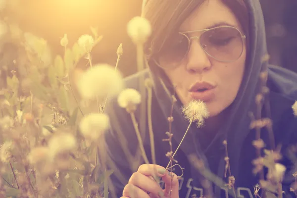 Vrouw waait paardebloem — Stockfoto