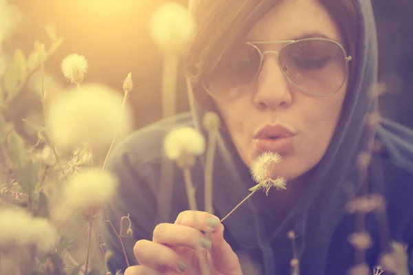 Woman blowing dandelion — Stock Photo, Image