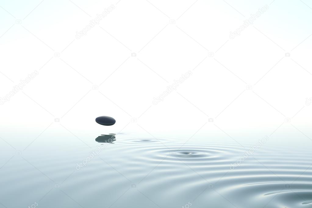 zen stone thrown on the water