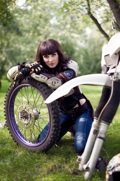 Girl repairs the wheel of motorcycle — Stock Photo, Image