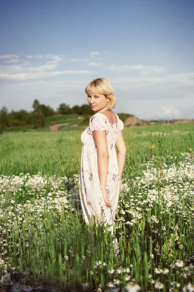 Hermosa chica en vestido en el campo de flores de margarita —  Fotos de Stock