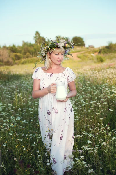 Beautiful girl in jug of milk in her hands — Stock Photo, Image