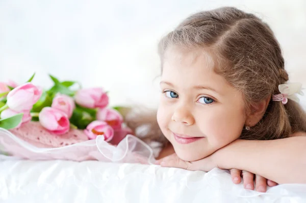 Menina deitada com tulipas rosa — Fotografia de Stock