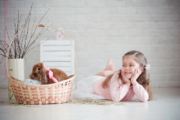 Girl lies near a basket with rabbit — Stock Photo, Image