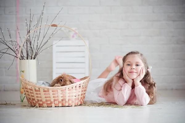 Menina fica perto de uma cesta com coelho — Fotografia de Stock