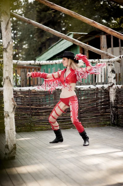 Jovem mulher vestindo vestido de cowboy vermelho na cena rural — Fotografia de Stock