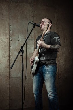 Şarkı söyleyen ve gitar çalan adam