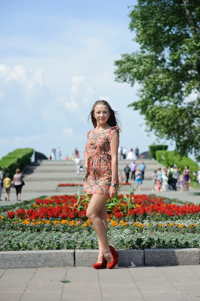 Girl posing near the flowerbeds — Stock Photo, Image