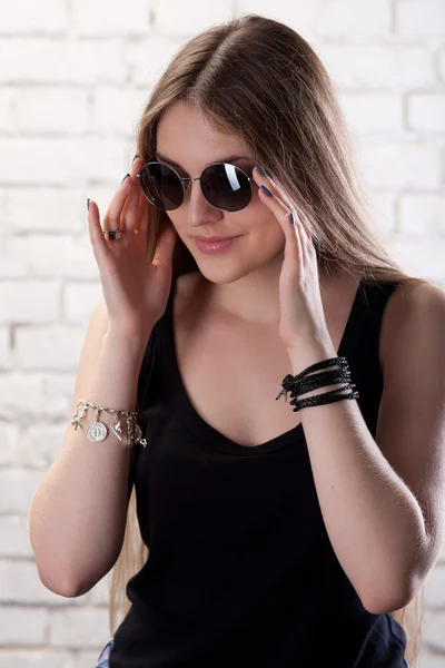 Girl posing in studio against a white brick wall — Stock Photo, Image