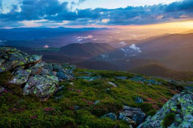 Karpatlar 'ın üzerinde akşam güneşiyle aydınlanan bulutlar. Ukrayna.