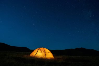 The starry sky above the tourist tent in the mountains. Eastern Carpathians.