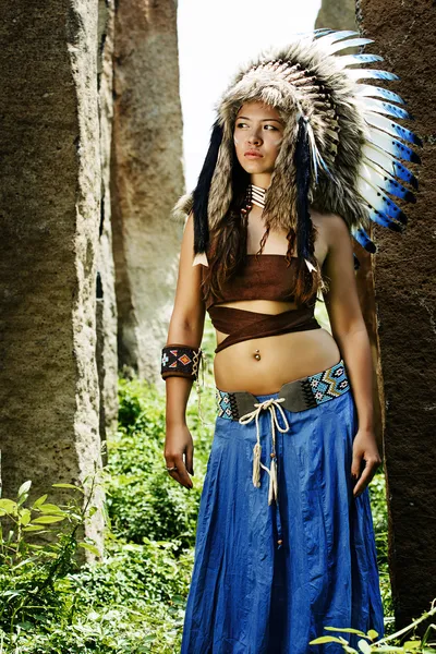 Native american, indians, in traditional dress stands tall in a grove of stone — Stock Photo, Image