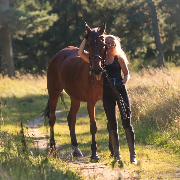 Blond girl embraces her horse — Stock Photo, Image