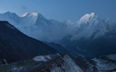 Manaslu bölgesindeki Himalayalar 'da sabah erken saatlerde dağ yamaçları ve tepeler karla kaplı.