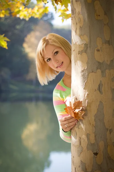 La chica mirando hacia fuera debido a un árbol — Foto de Stock