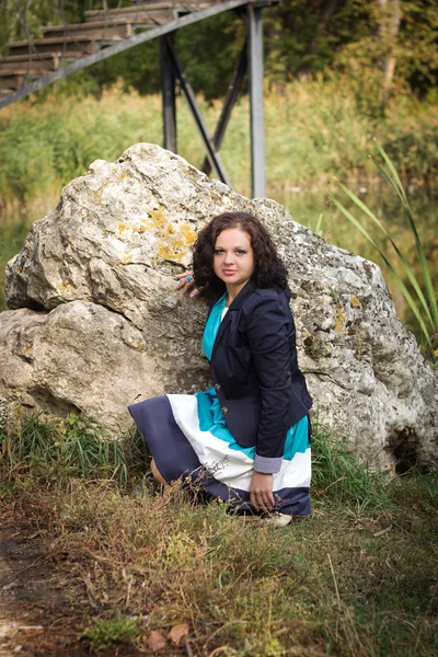 La chica cerca de una gran piedra en el parque —  Fotos de Stock