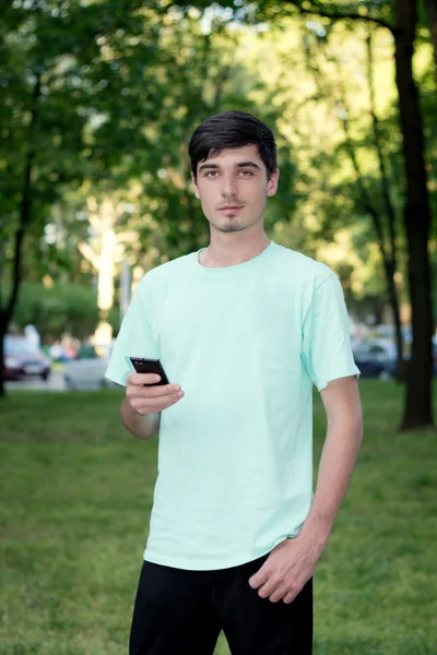 Attractive young guy outdoors calls by telephone — Stock Photo, Image