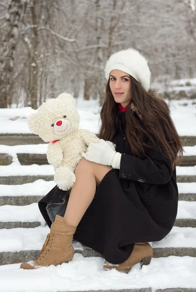 Fröhliche kaukasische junge Frau hält bei verschneitem Wetter ein Spielzeug in der Hand — Stockfoto