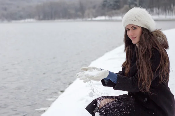 Fröhliche kaukasische junge Frau bei schneebedecktem Wetter am Ufer des — Stockfoto