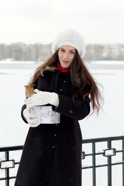 Alegre mujer joven caucásica en clima nevado abre una caja con — Foto de Stock