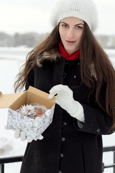 Веселая белая молодая женщина в снежную погоду открывает коробку с — стоковое фото