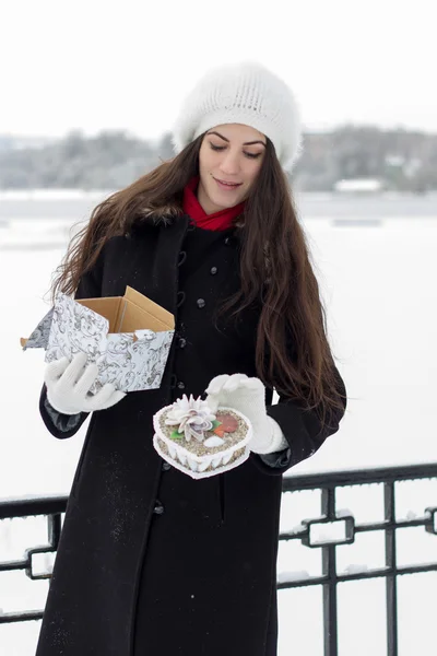 Веселая белая молодая женщина в снежную погоду получает подарок от — стоковое фото