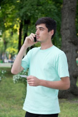 çekici genç adam açık havada telefonla aramalar