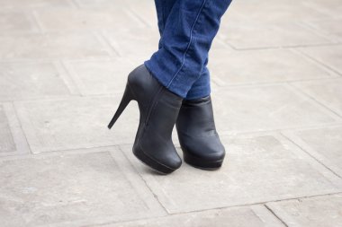 Kızın bacağını ile siyah çizmeler yüksek topuk üzerinde.