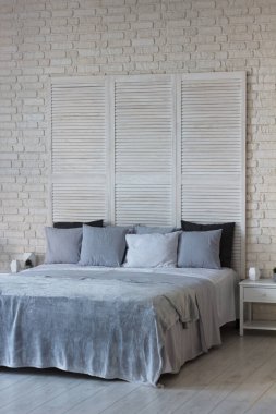 Yatak odasının içi açık renkli. Yastıklı ve örtülü bir yatak var. Uyumak için harika bir yer.