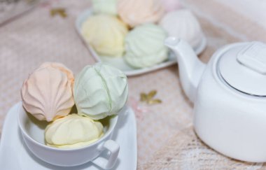 Çay partisi zamanı. Masa örtüsüyle servis edilen bir masada sersemletici bir taze marşmelov ve sert kokulu bir çaydanlık uzanır.