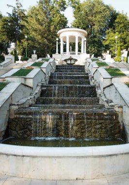 Restored rotunda and cascade ladder filled with water in the park pleases visitors. Fine modern architectural construction