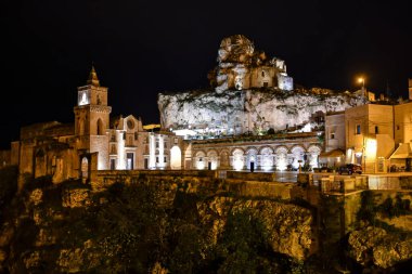 Matera 'nın gece manzarası, kayanın içine inşa edilmiş antik bir şehir. İtalya 'nın Basilicata bölgesinde yer almaktadır..