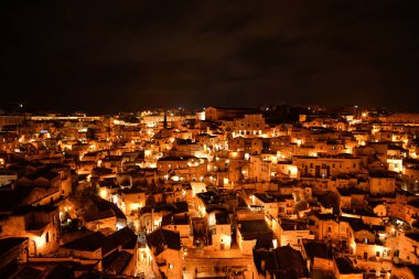 Matera 'nın gece manzarası, kayanın içine inşa edilmiş antik bir şehir. İtalya 'nın Basilicata bölgesinde yer almaktadır..