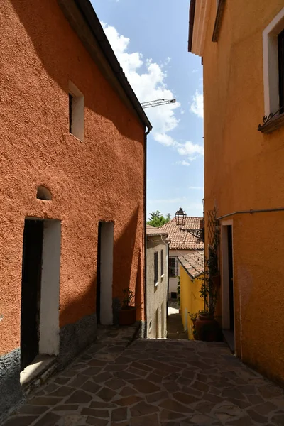 A narrow street between the old houses of Sasso di Castalda, a village in the mountains of Basilicata, Italy.