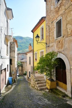 İtalya 'nın Salerno eyaletindeki bir ortaçağ köyü olan Teggiano' nun eski evleri arasında dar bir sokak..