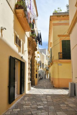 A narrow street between the old houses of Gallipoli, an Apulian village in the province of Lecce, Italy.