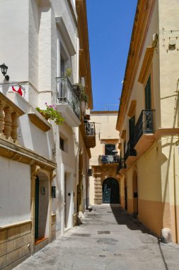 A narrow street between the old houses of Gallipoli, an Apulian village in the province of Lecce, Italy.