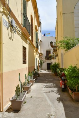 A narrow street between the old houses of Gallipoli, an Apulian village in the province of Lecce, Italy.