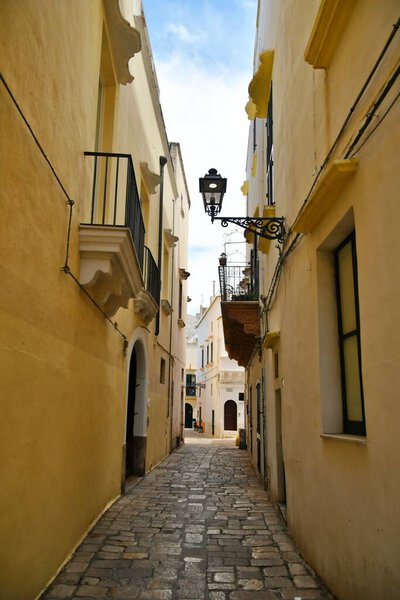 A narrow street between the old houses of Gallipoli, an Apulian village in the province of Lecce, Italy.