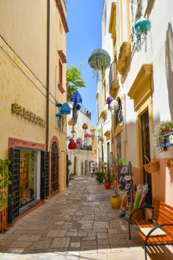 A narrow street between the old houses of Gallipoli, an Apulian village in the province of Lecce, Italy.