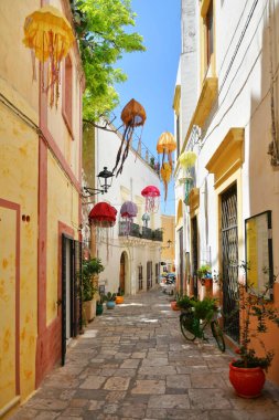 A narrow street between the old houses of Gallipoli, an Apulian village in the province of Lecce, Italy.