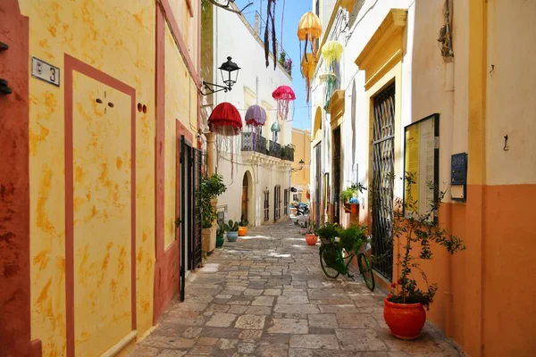 A narrow street between the old houses of Gallipoli, an Apulian village in the province of Lecce, Italy.